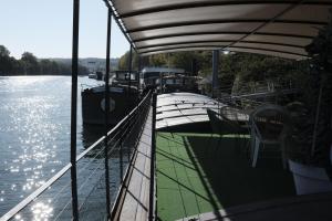 a boat deck with a table and chairs on the water at Belle péniche romantique à Paris in Boulogne-Billancourt
