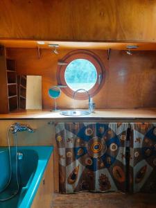 a small bathroom with a sink and a window at Belle péniche romantique à Paris in Boulogne-Billancourt