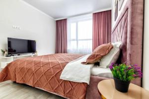 1 dormitorio con 1 cama grande y TV en 1-комнатная Квартира в Астане en Astaná