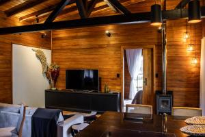 uma sala de estar com painéis de madeira e uma televisão em Villa Vida. Sua cabana entre Urubici e São Joaquim - Serra Catarinense em São Joaquim