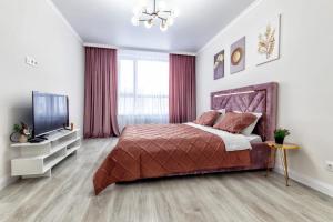 1 dormitorio con 1 cama y TV de pantalla plana en 1-комнатная Квартира в Астане en Astaná