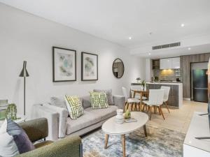 een woonkamer met een bank en een tafel bij Newstead Modern 2-storey Apartment - Q Stay in Brisbane