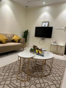 a living room with a couch and a table at شقة مفروشة بدخول ذاتي in Al Kharj