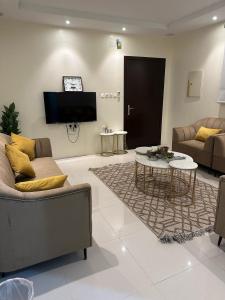 ein Wohnzimmer mit 2 Sofas und einem Tisch in der Unterkunft شقة مفروشة بدخول ذاتي in Al Kharj