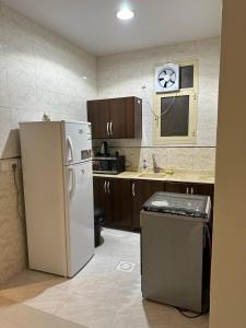 a kitchen with a white refrigerator and a sink at شقة مفروشة بدخول ذاتي in Al Kharj