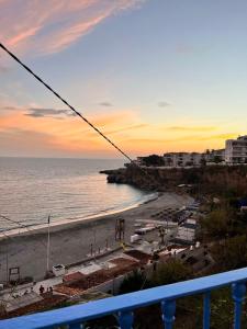 ネルハにあるCosta Suri Apartamentoのバルコニーからビーチの夕日の景色を望めます。