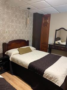 1 dormitorio con cama, tocador y espejo en Hotel Ensueños, en Cuenca