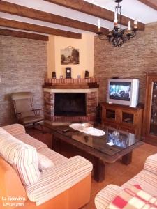 sala de estar con chimenea y TV en La Golondrina, en Cáñar