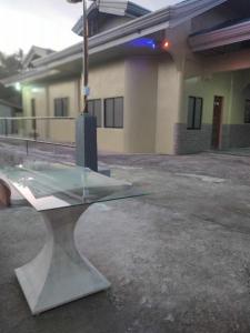 a glass table sitting in front of a building at Oslob Hilltop Transient House in Cañang