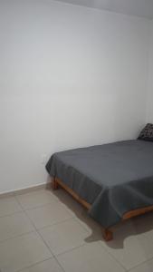 a bedroom with a bed with a gray blanket on it at Yecapixtla in Yecapixtla