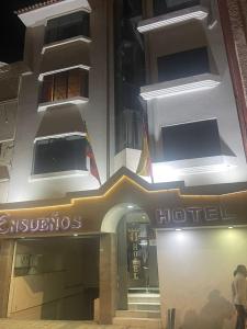 una tienda frente a un hotel por la noche en Hotel Ensueños, en Cuenca