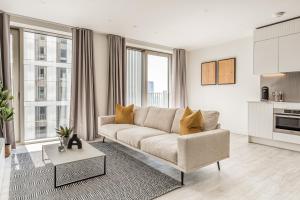 a living room with a couch and some windows at Urban Rest Stratford Apartments in London