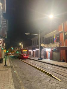 Un tren rojo está en las vías por la noche en Hotel Ensueños, en Cuenca