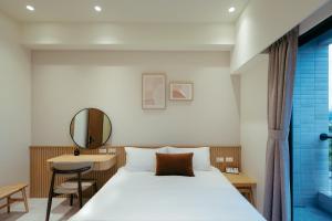 a bedroom with a bed and a desk and a mirror at 參穗 SunSui B&B in Dongshan