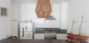 a white kitchen with a refrigerator and a stove at Tigre Studio Apartment in Tigre