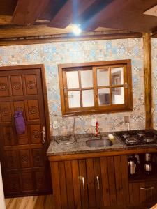 a kitchen with a sink and a window at Casa de aluguel praia do rosa in Garopaba