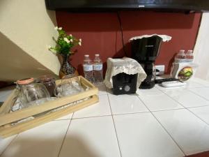 eine Arbeitsplatte mit Wasserflaschen und eine Kaffeemaschine in der Unterkunft Habitación Privada Andrea, en la Isla in Flores