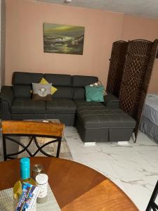 ein Wohnzimmer mit einem schwarzen Sofa und einem Tisch in der Unterkunft Towers by the Beach in Ocho Rios