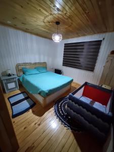 um quarto com uma cama e um sofá em Cabaña en Contulmo em Contulmo