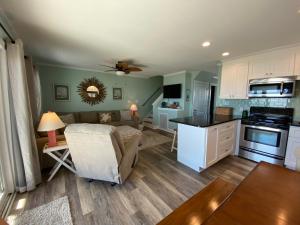 a kitchen and living room with a couch and a table at 2 if by Sea- East Unit in Emerald Isle