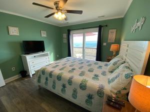 um quarto com uma cama e uma ventoinha de tecto em 2 if by Sea- East Unit em Emerald Isle