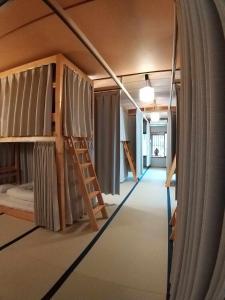 a room with bunk beds with a ladder in it at Magome Chaya in Nakatsugawa