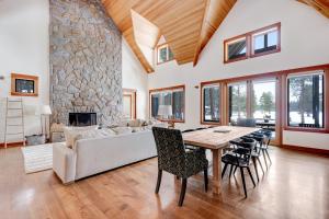 a living room with a table and a stone fireplace at Meadowview Haven in Black Butte Ranch