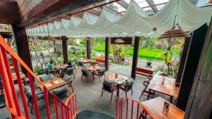 an outdoor dining area with tables and chairs at AnandaDara Ubud in Ubud