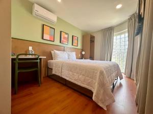 a bedroom with a bed and a desk and a window at INTJ Hotel in Tijuana