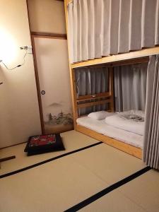 a bedroom with two bunk beds and a book at Magome Chaya in Nakatsugawa