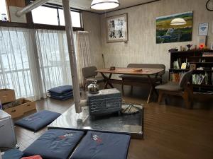 a living room with a table and a dining room at noukanoyado seisetsukan in Senboku