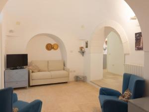 - un salon avec un canapé et une télévision dans l'établissement Holiday home Trullo Tre Corbezzoli, Ostuni, à Ostuni