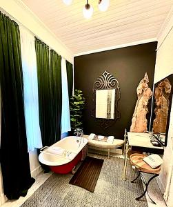een badkamer met een bad en een wastafel bij Summerville Maisonettes Triplex in Augusta