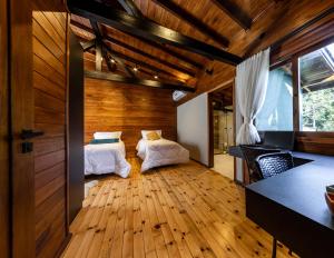 two beds in a room with wooden floors at Villa Vida. Sua cabana entre Urubici e São Joaquim - Serra Catarinense in São Joaquim