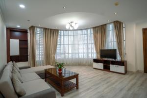 a living room with a couch and a tv at HAMPTONS Apartments in Phnom Penh