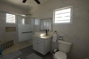 uma casa de banho com um WC, um lavatório e uma janela em Sunset Seclusion. em The Valley