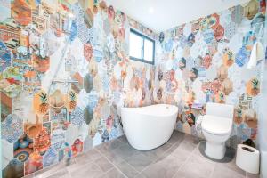uma casa de banho com um WC e uma parede em mosaico em Penghu I Stay II em Magong