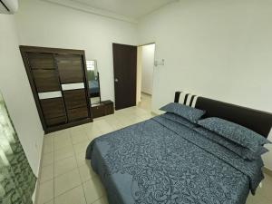 a bedroom with a blue bed and a dresser at A&H Homestay Seberang Jaya with Swimming Pool & 3 Bedroom AC in Permatang Janggus