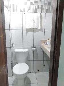 Baño blanco con aseo y lavamanos en HOTEL NOVAES, en Castanhal