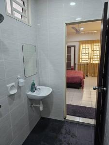 a bathroom with a sink and a bed in a room at A&H Homestay Seberang Jaya with Swimming Pool & 3 Bedroom AC in Permatang Janggus