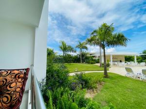 balcón con vistas a un patio con palmeras en Vista Golf II Playa Nueva Romana, en San Pedro de Macorís