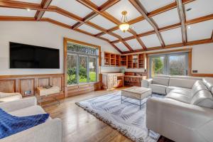 a living room with couches and a flat screen tv at Perched on the Bluff - Main Home in Mendocino