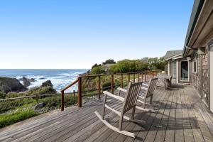 two chairs sitting on a deck looking at the ocean at Luxe Remodeled Oceanfront Home on the Bluff in Mendocino