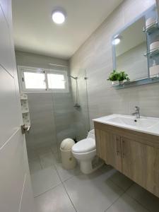 a white bathroom with a toilet and a sink at Vista Golf II Playa Nueva Romana in San Pedro de Macorís