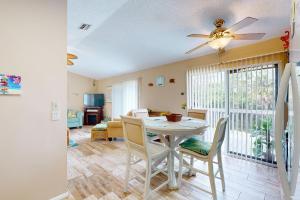 a dining room and living room with a ceiling fan at Salt, Sand, Sea in North Port +18 photos