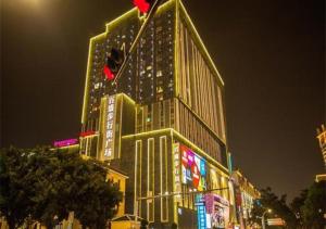 wysoki budynek z oświetleniem w nocy w obiekcie City Comfort Inn Nanning Chaoyang Parkson Pedestrian Street w mieście Nanning