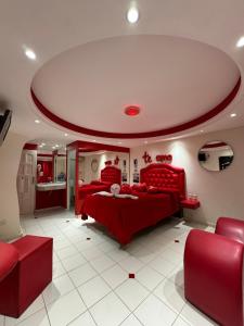 um quarto com uma cama vermelha e cadeiras vermelhas em Hotel venus em Villa Mercedes