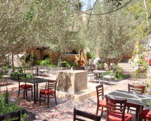 un patio con tavoli, sedie e alberi di Hotel Boutique La Granja a Tequisquiapan