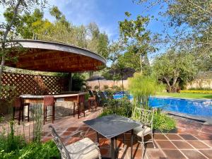 a patio with a table and chairs next to a pool at Hotel Boutique La Granja in Tequisquiapan