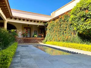 a house with a swimming pool in front of a wall at Hotel Boutique La Granja in Tequisquiapan
